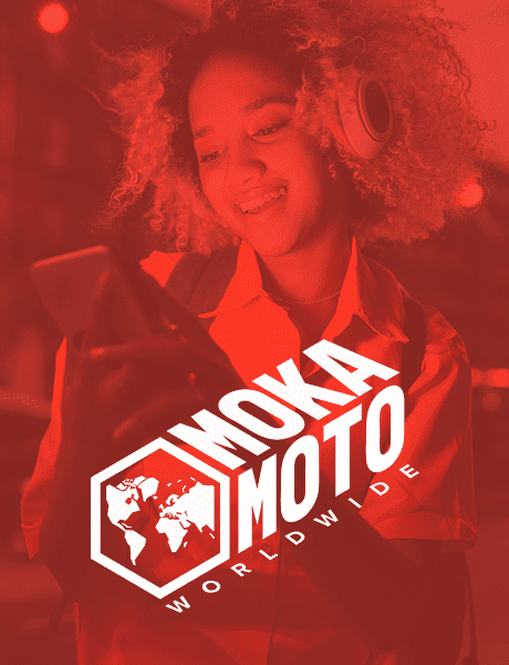 Smiling woman with curly hair wearing headphones and looking at her phone, with the MokaMoto Worldwide logo in bold white text and a hexagonal icon featuring a world map.