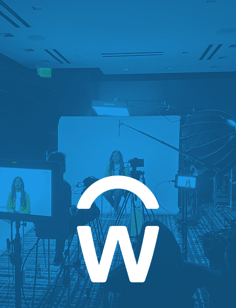 Behind-the-scenes photo of a video production set with cameras and lighting, tinted in blue and featuring the Workday logo prominently in the center.